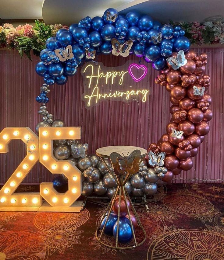 Anniversary decoration in Hyderabad with a balloon arch, candles and rose petal styling