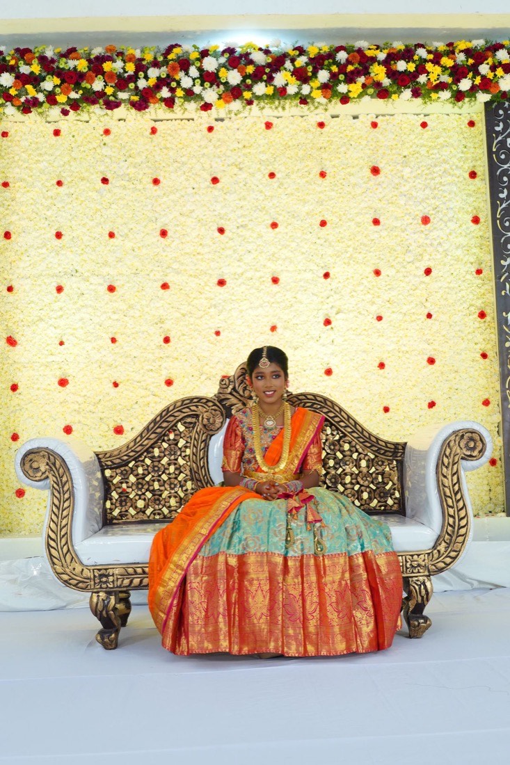 Half saree function stage in Hyderabad with floral pillars and decorated ceremonial seating