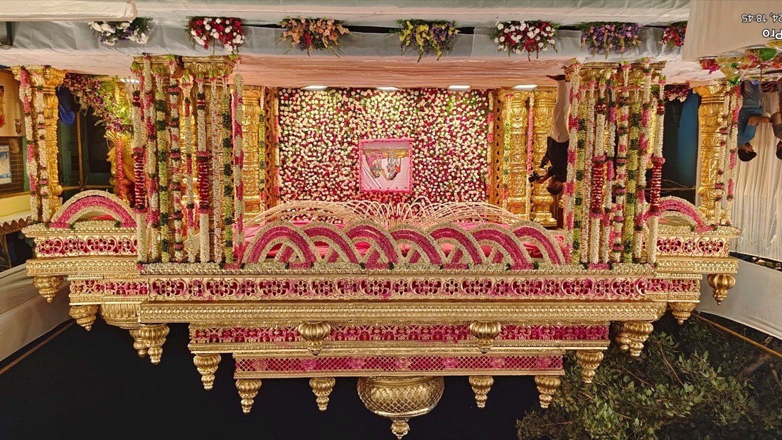 Grand gold marriage mandap in Hyderabad with pink and white floral arches and a full flower backdrop