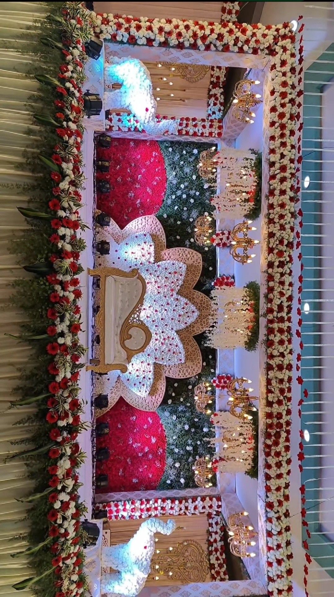 Wedding reception decoration in Hyderabad with a tall floral backdrop and lit stage