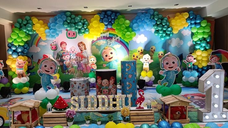 Cartoon theme first birthday decoration in Hyderabad with a blue and green balloon arch and character cutouts