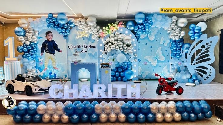 Little Man theme first birthday decoration in Hyderabad with a blue balloon arch, shimmer wall and light-up name letters