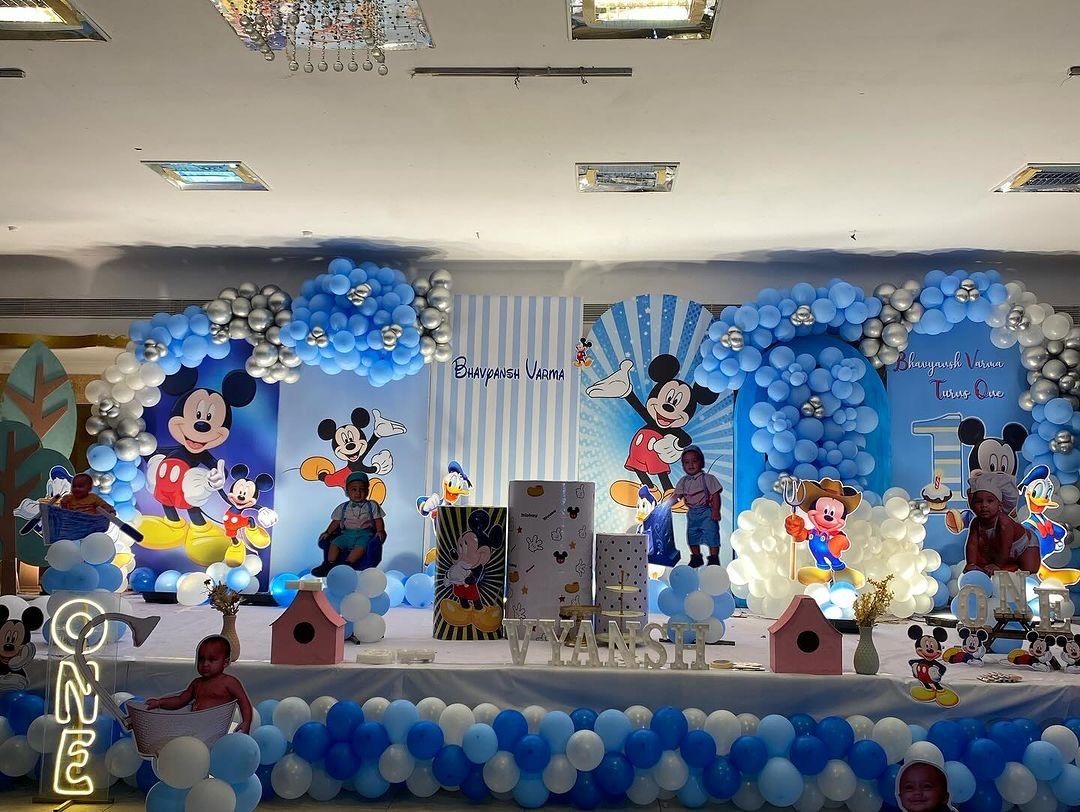 Mickey Mouse theme first birthday decoration in Hyderabad with a blue and white balloon garland and cutout backdrop