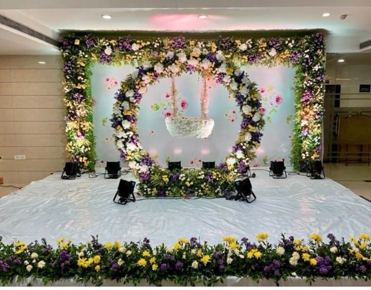 Floral arch stage with a hanging flower swing, the same swing build used for mehndi setups in Hyderabad