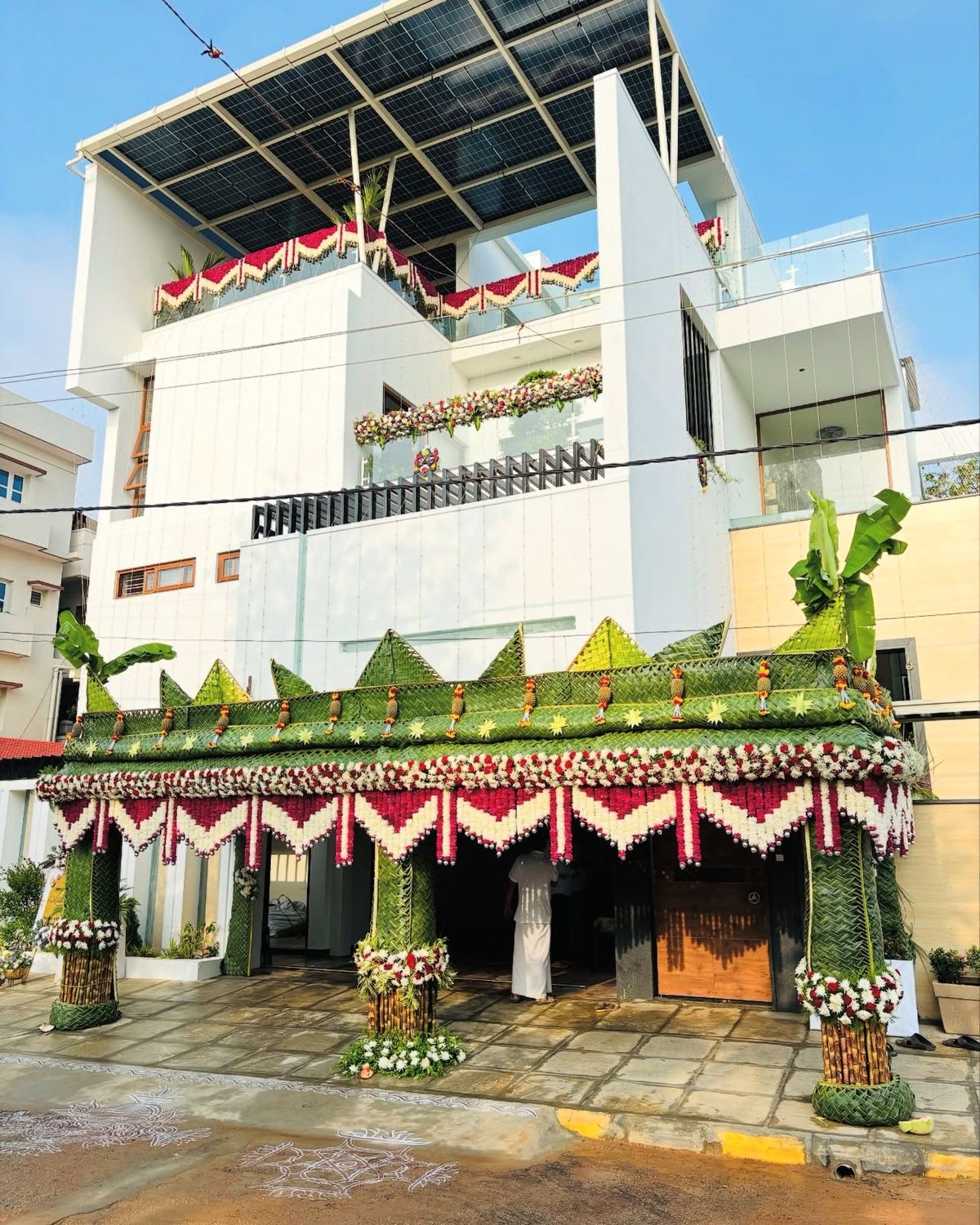 Gruhapravesham house warming decoration in Hyderabad with a palm leaf pandal, marigold and rose torans and a rangoli at the entrance